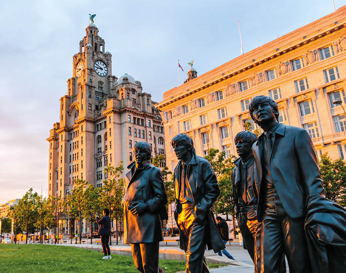 LIVERPOOL, ENGLAND - MAY 18, 2019 : Bronze statue of the Beatles; stand on Liverpoolâ  s Pier Head waterfront on the side of River Mersey, sculpted by Andrew Edwards, photo shooting in the evening 