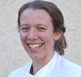 A person smiling for the camera Description automatically generated