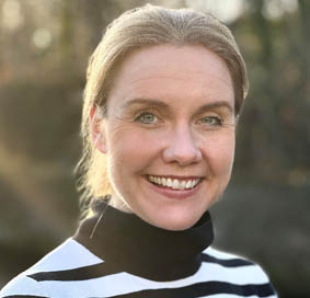 A person smiling for the camera Description automatically generated