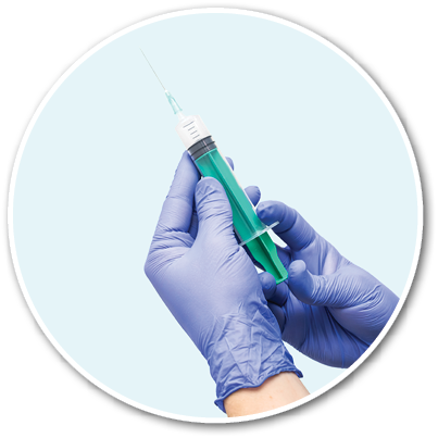 Doctor's hands in latex protective gloves hold a disposable syringe with a needle filled with injection for intramuscular injection on a blue background. Vaccination against influenza, covid, rabies.