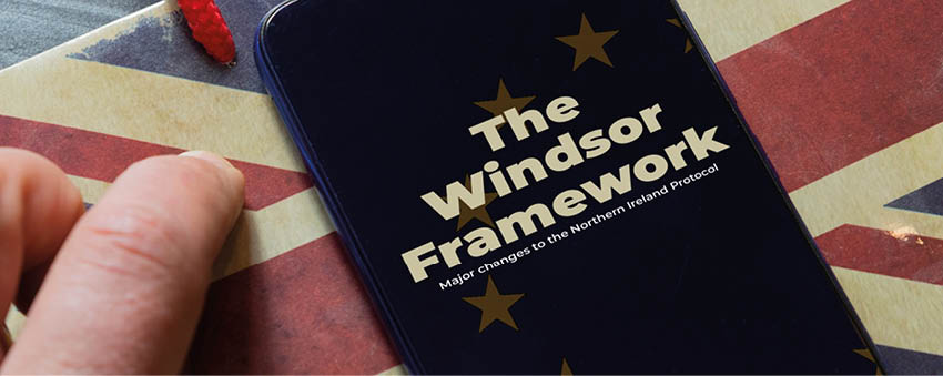 Windsor framework agreement concept: smartphone over a paper bag on a wooden table