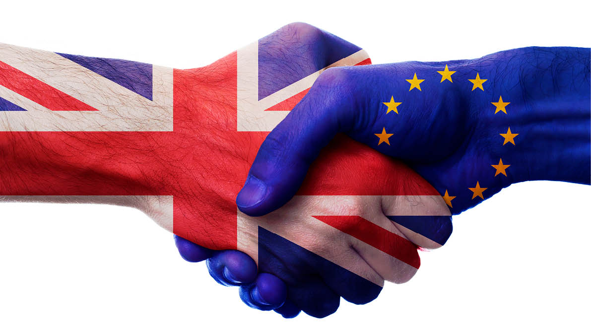 UK and European Union bilateral political relations and cooperation concept with Union Jack flag and EU flag painted on handshake.