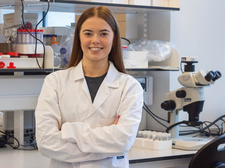 A woman in a lab coat poses for a picture. AI generated content