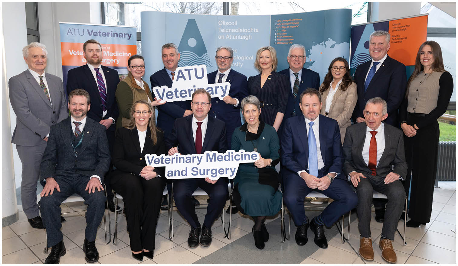 A group of people posing for a photo in front of a sign that says “A.T.U. Veterinary Medicine and Surgery". AI generated content