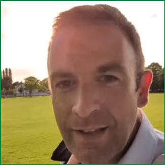 A man is standing in a field, smiling and looking at the camera. AI generated content