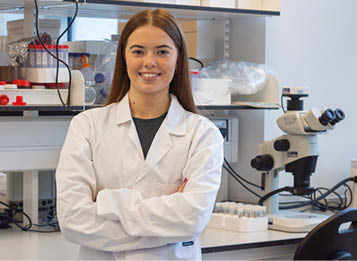 A woman in a lab coat poses for a picture. AI generated content