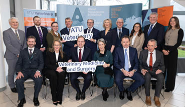 A group of people posing for a photo in front of a sign that says “A.T.U. Veterinary Medicine and Surgery". AI generated content