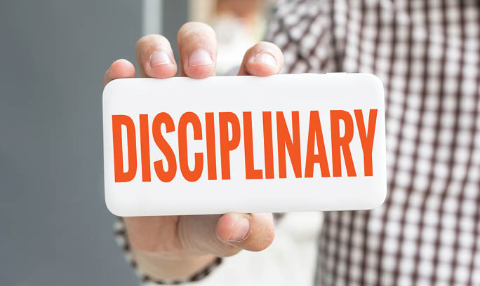 Man hand showing DISCIPLINARY word phone with  blur business man wearing plaid shirt 