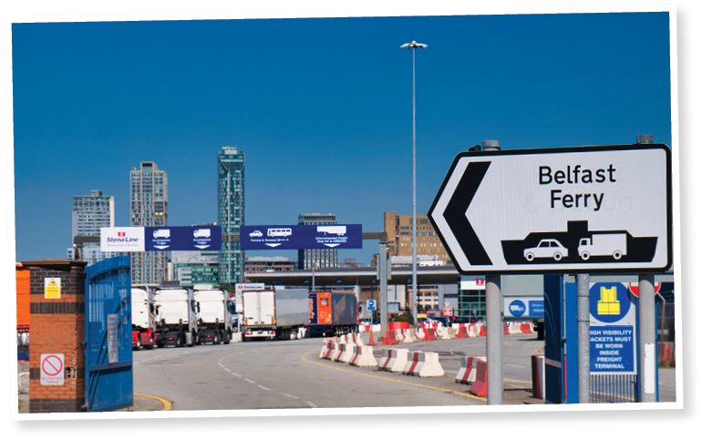 Wirral, UK - Jul 17 2021: With foreground focus set on the Belfast Ferry sign, lorries queue the Stena Line roll on - roll off Liverpool to Belfast ferry Terminal in Birkenhead on the River Mersey.