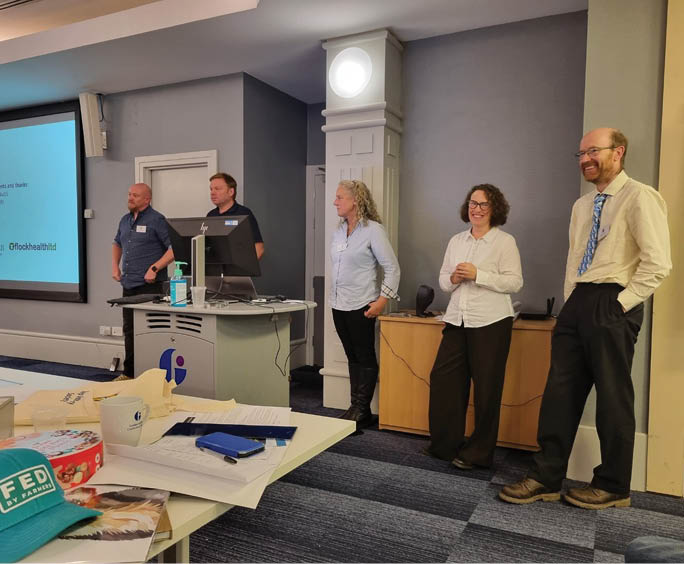 A group of people standing in a room Description automatically generated